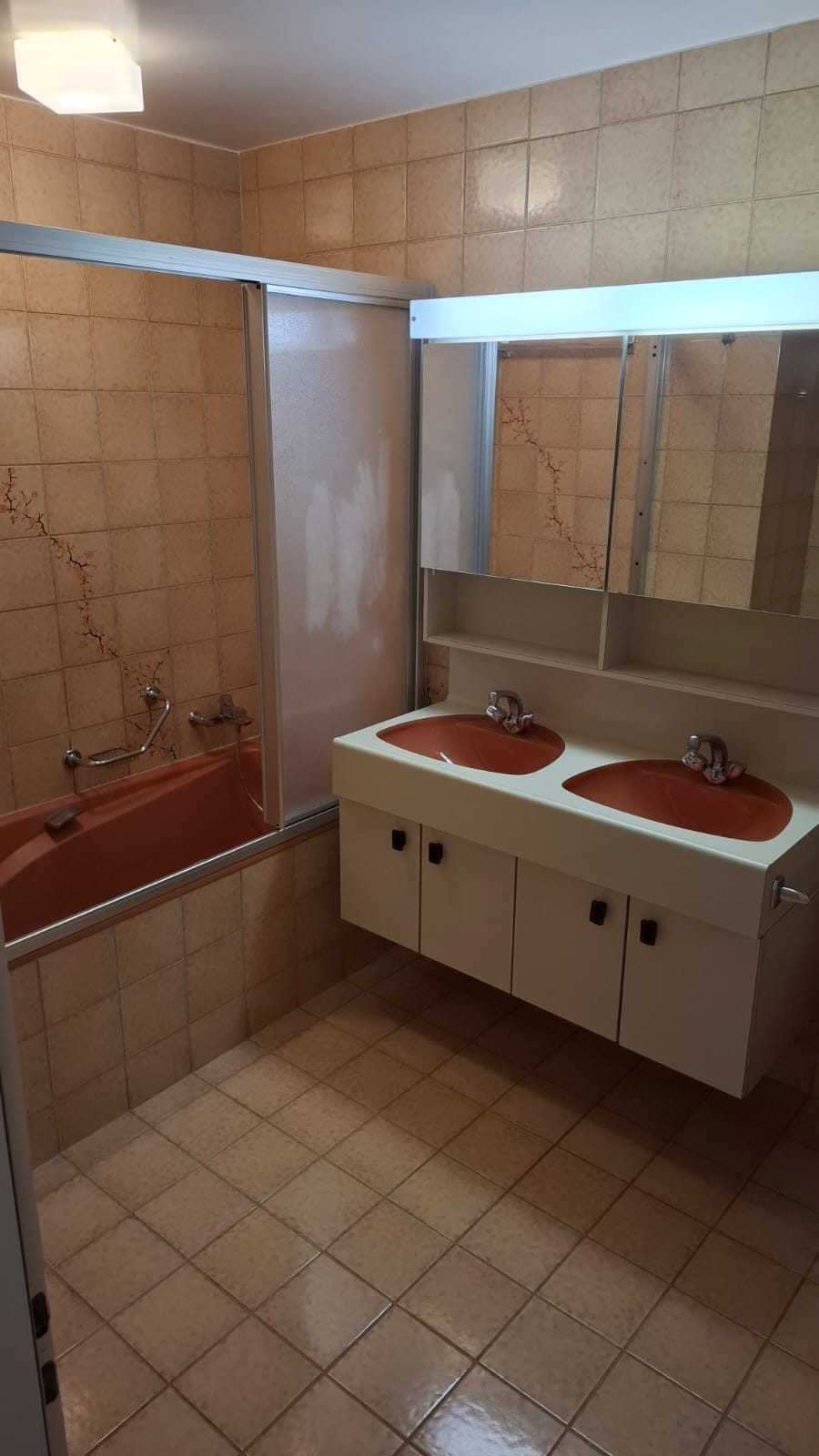 Avant renovation : salle de bain vetuste dans une villa a Corseaux, carrelage abime et baignoire datee