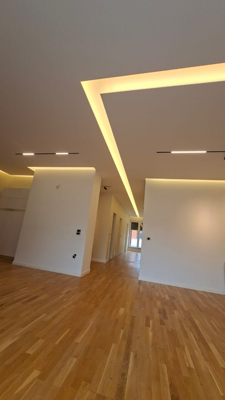 Sejour renove avec faux-plafond LED, spots encastres et parquet, appartement La Baie d'Opale a Rolle