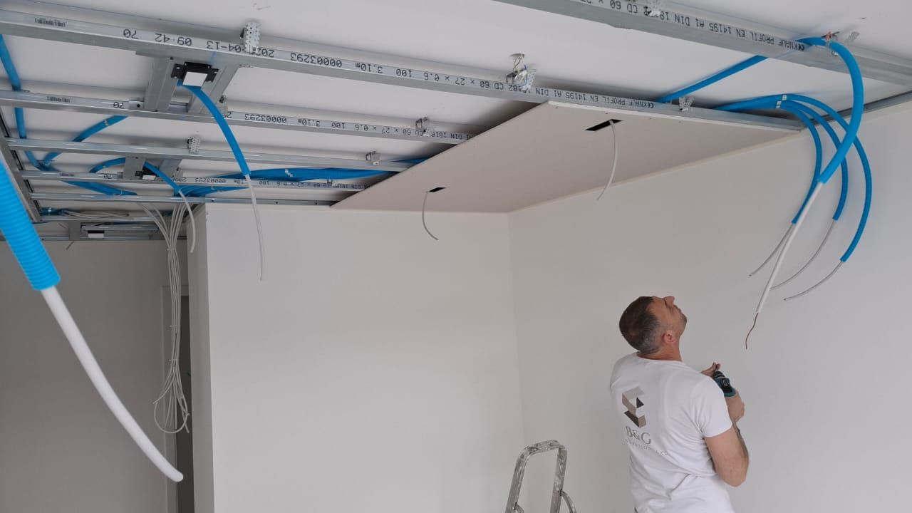 Equipe BNG Renovation posant l'ossature et les plaques du faux-plafond, chantier La Baie d'Opale a Rolle